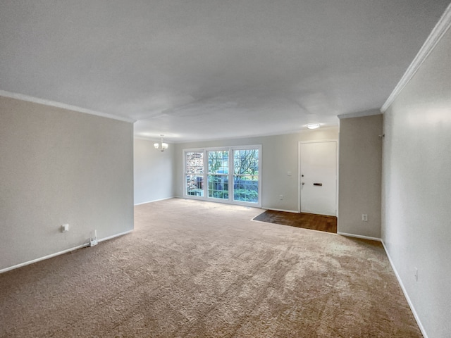 empty room featuring carpet flooring, crown molding, a textured ceiling, and a notable chandelier