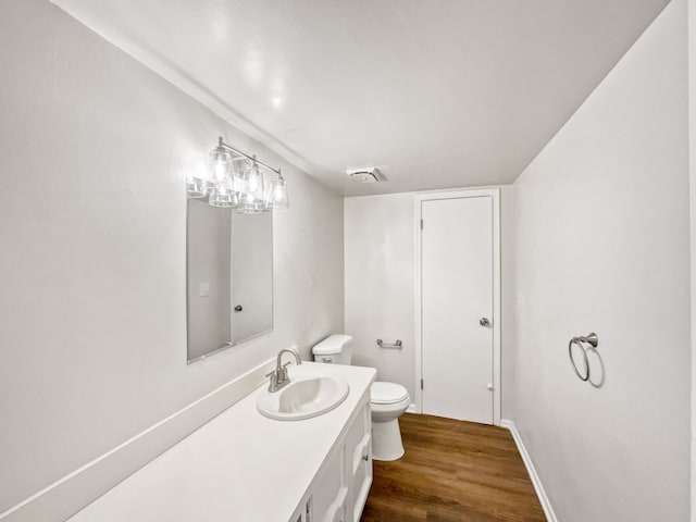 bathroom with hardwood / wood-style floors, vanity, and toilet