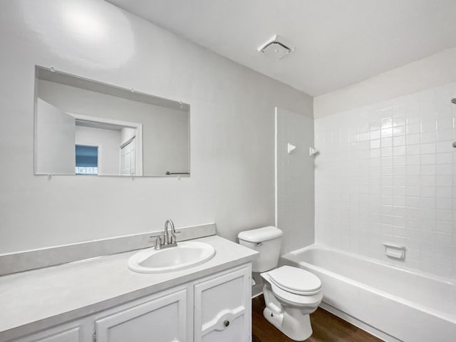 full bathroom with vanity, hardwood / wood-style flooring, toilet, and tiled shower / bath