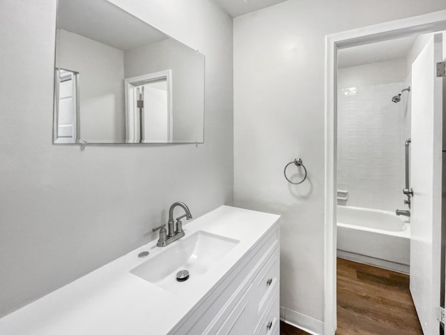 bathroom featuring wood-type flooring, vanity, and tiled shower / bath