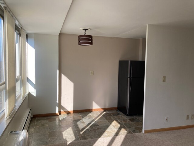 8900 E Jefferson Ave Unit 1431, Detroit, MI 48214 - spare room featuring baseboards, dark stone finish floors, and a baseboard heating unit