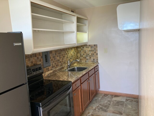 8900 E Jefferson Ave Unit 1431, Detroit, MI 48214 - kitchen with black electric range, freestanding refrigerator, a sink, tasteful backsplash, and baseboards