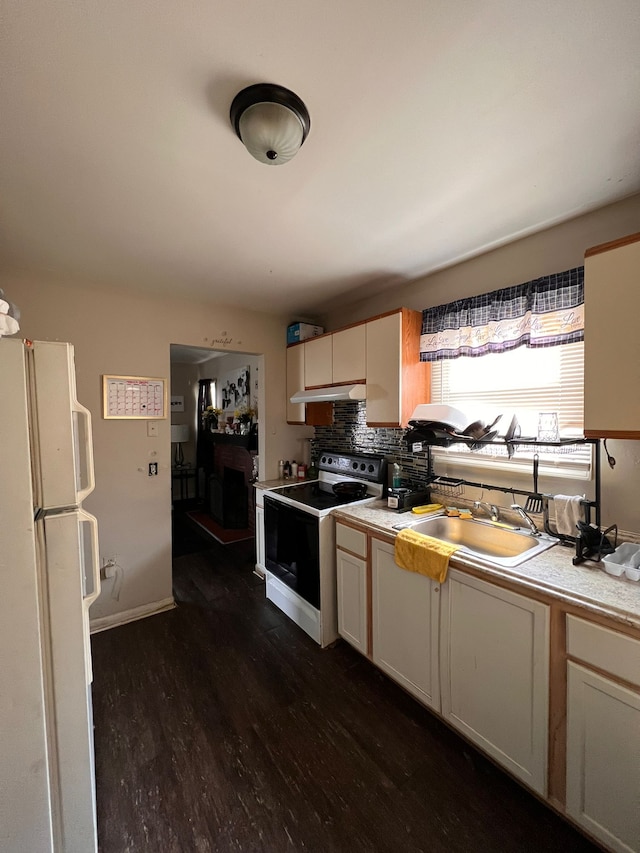 kitchen with dark hardwood / wood-style flooring, decorative backsplash, sink, and white appliances