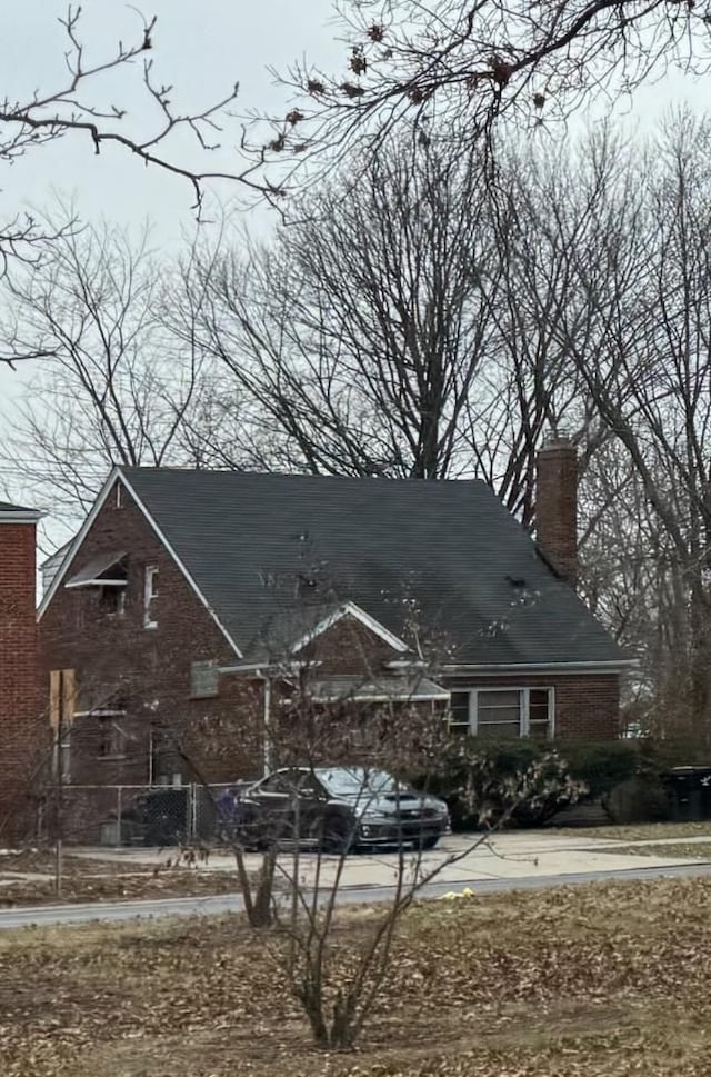 20920/2 Moross Rd, Grosse Pointe, MI 48236 - view of front of home with a chimney, brick siding, and driveway