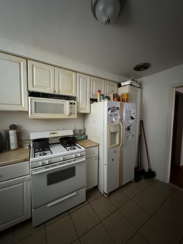 kitchen featuring tile patterned floors, white appliances, and cream cabinets