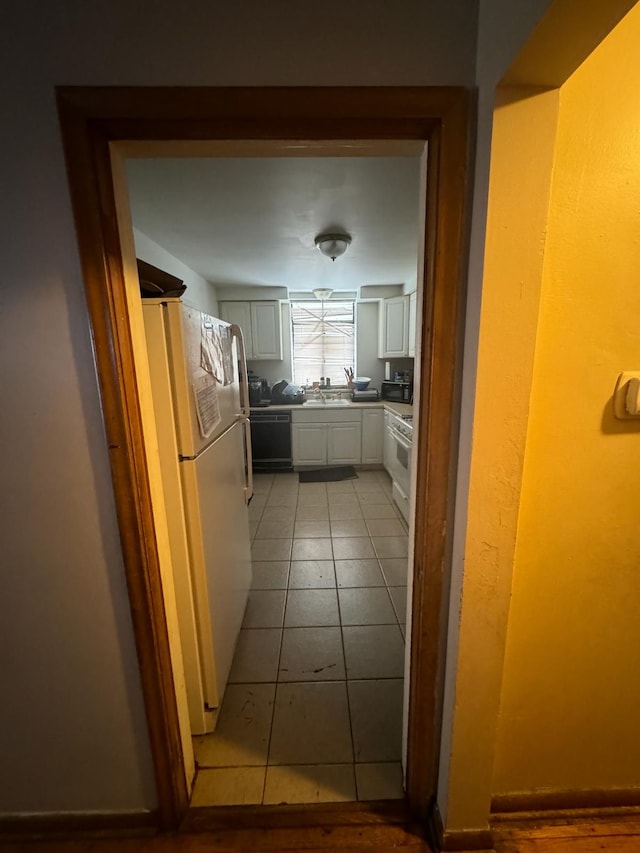 kitchen featuring dishwasher, light tile patterned flooring, white cabinets, sink, and white fridge