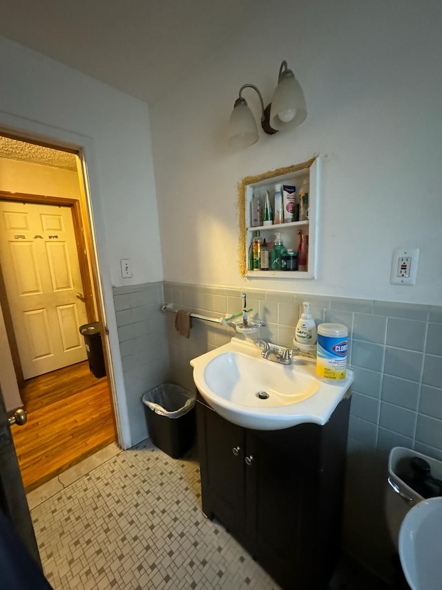 bathroom with wood-type flooring, vanity, and tile walls