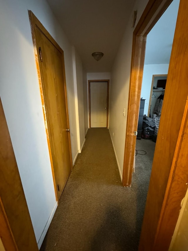 hall with dark colored carpet