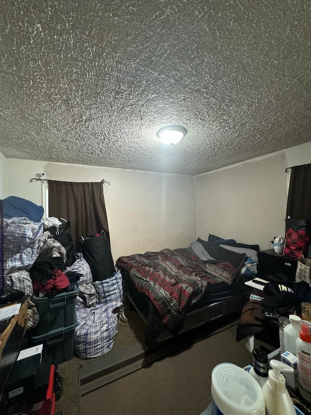 bedroom with carpet floors and a textured ceiling