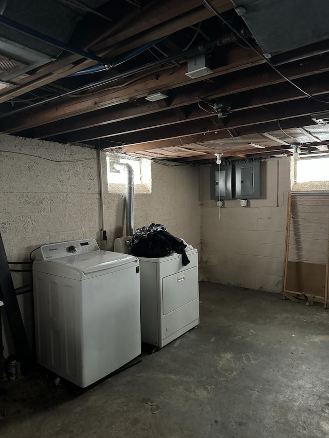 clothes washing area featuring electric panel and washer and clothes dryer