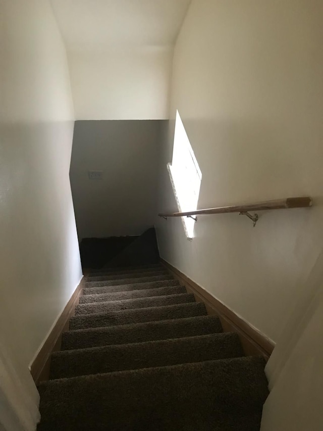 stairs with carpet flooring and lofted ceiling