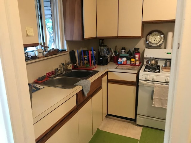 20920/2 Moross Rd, Grosse Pointe, MI 48236 - kitchen featuring gas range gas stove, light countertops, a sink, and light tile patterned floors