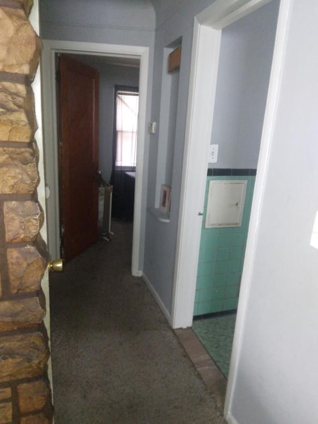 hallway featuring dark colored carpet