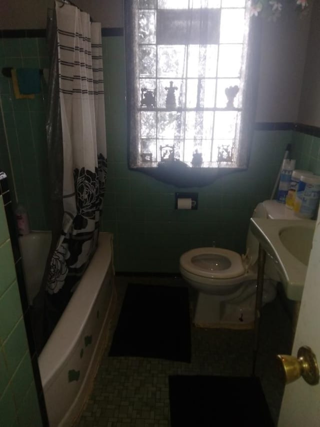 full bathroom featuring sink, shower / bath combo, tile walls, and toilet