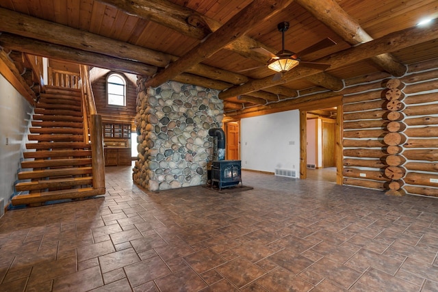 unfurnished living room featuring a wood stove, log walls, and wood ceiling