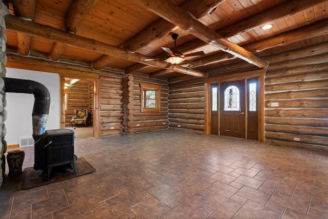 living room with a wood stove, ceiling fan, log walls, wooden ceiling, and beamed ceiling