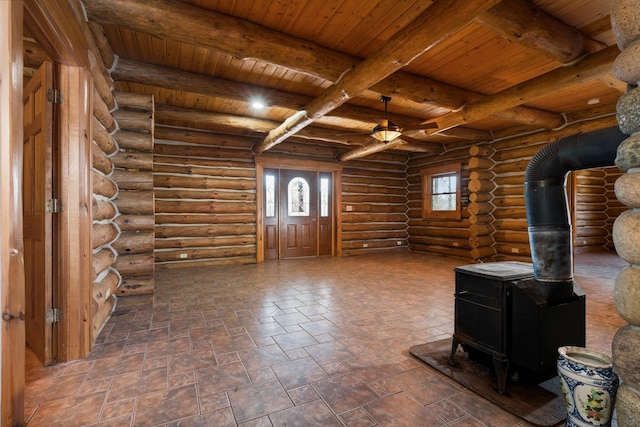 unfurnished living room with a wood stove, beamed ceiling, log walls, and wood ceiling