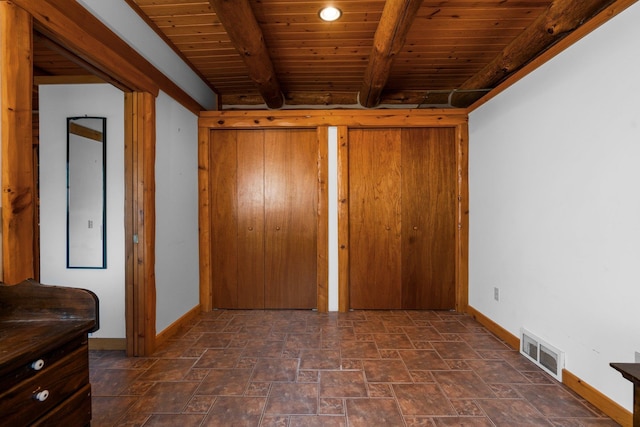 unfurnished bedroom featuring beamed ceiling and wood ceiling