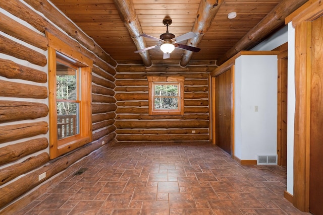 unfurnished room featuring beam ceiling, rustic walls, ceiling fan, and wooden ceiling