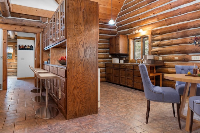 kitchen with pendant lighting, sink, and rustic walls