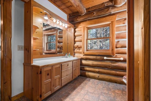 bathroom featuring beam ceiling, rustic walls, vanity, and wooden ceiling