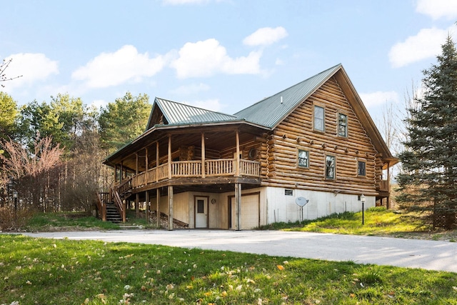 exterior space featuring a yard, a garage, and a wooden deck