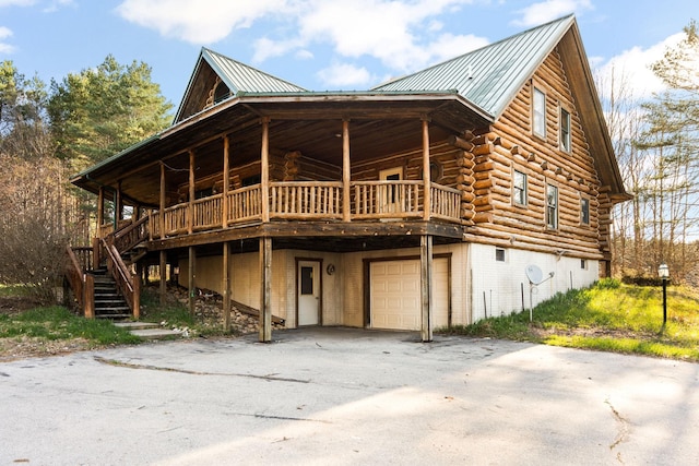 back of property featuring a garage and a wooden deck