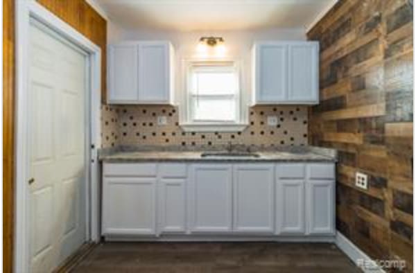 kitchen featuring backsplash, white cabinetry, and sink