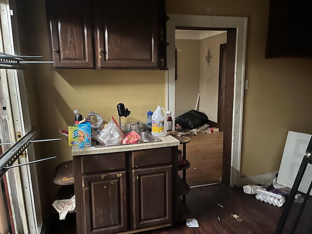 kitchen with sink, dark brown cabinetry, and dark wood-type flooring