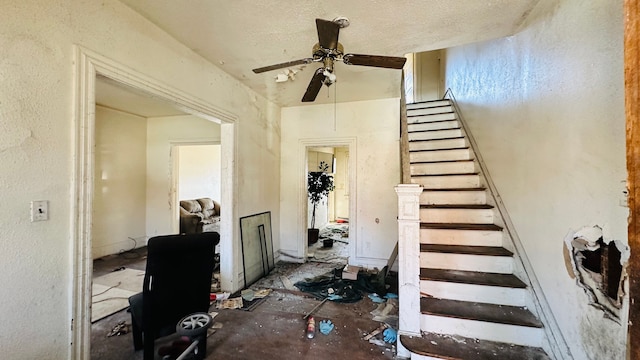 stairway featuring ceiling fan