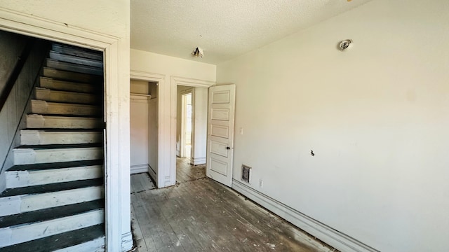 interior space featuring wood-type flooring and a textured ceiling