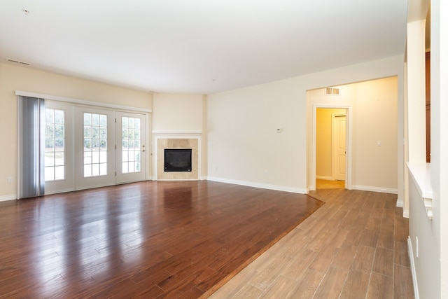 unfurnished living room with hardwood / wood-style floors and a tile fireplace