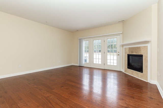 unfurnished living room with dark hardwood / wood-style floors and a tile fireplace