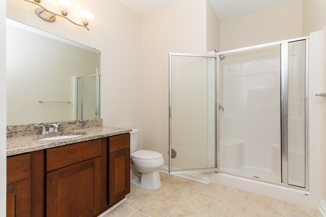 bathroom featuring tile patterned flooring, vanity, a shower with shower door, and toilet