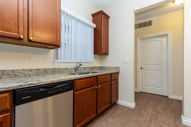 kitchen with dishwasher, dark hardwood / wood-style floors, light stone counters, and sink