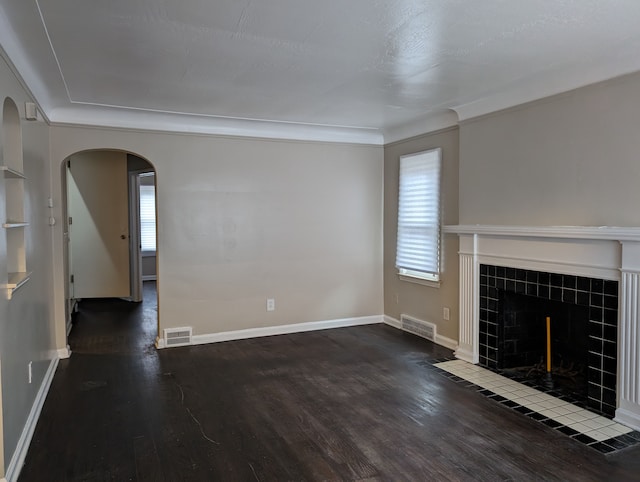 unfurnished living room with a fireplace, dark hardwood / wood-style floors, and crown molding