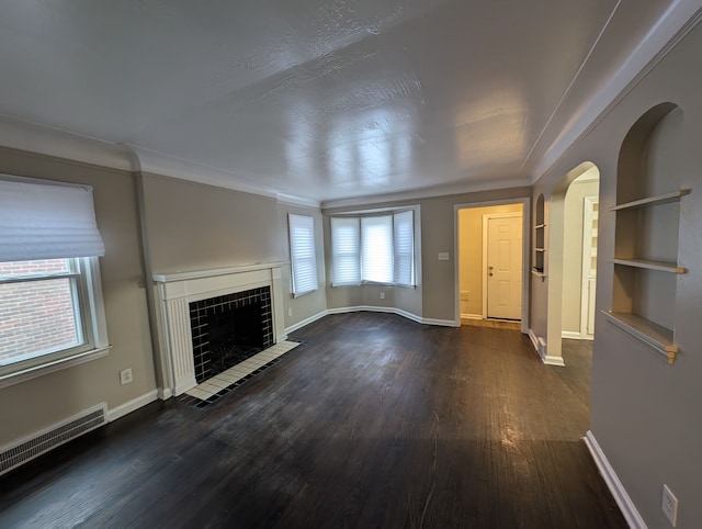 unfurnished living room with a tiled fireplace and dark hardwood / wood-style floors