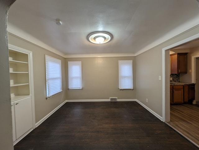 unfurnished dining area with dark wood-type flooring