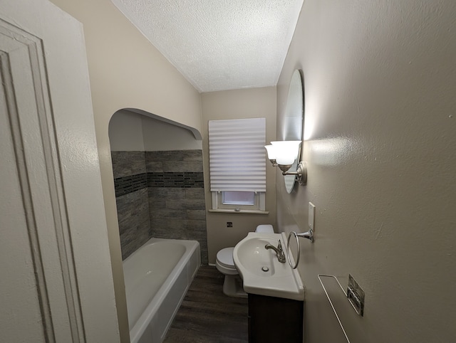 bathroom featuring wood-type flooring, vanity, a textured ceiling, and toilet