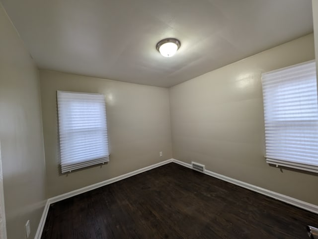 spare room featuring dark wood-type flooring