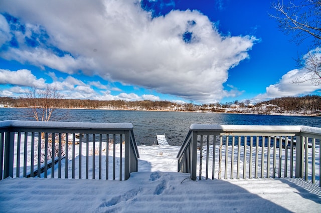 snow covered deck featuring a water view