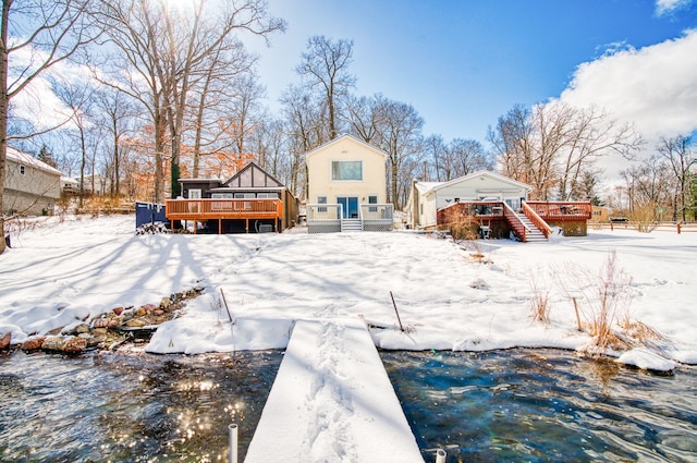 snow covered house featuring a wooden deck