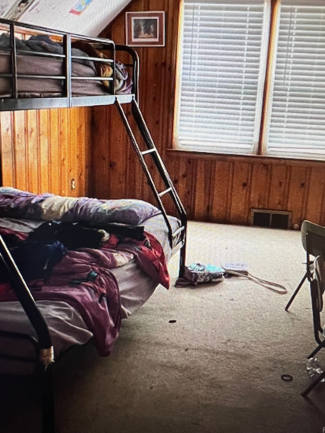 carpeted bedroom with wood walls