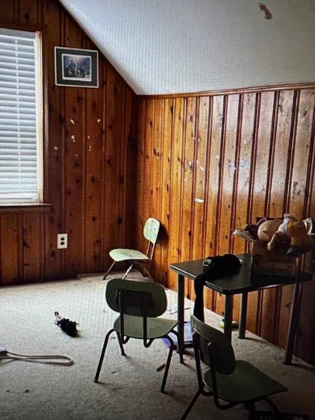 15920 Bramell St, Detroit, MI 48223 - living area with wood walls, lofted ceiling, and carpet flooring