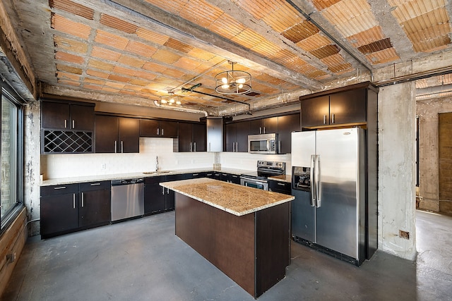 kitchen with sink, decorative light fixtures, dark brown cabinets, a kitchen island, and appliances with stainless steel finishes