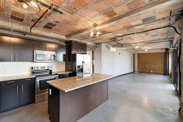 kitchen featuring light stone counters, dark brown cabinets, stainless steel appliances, pendant lighting, and a kitchen island