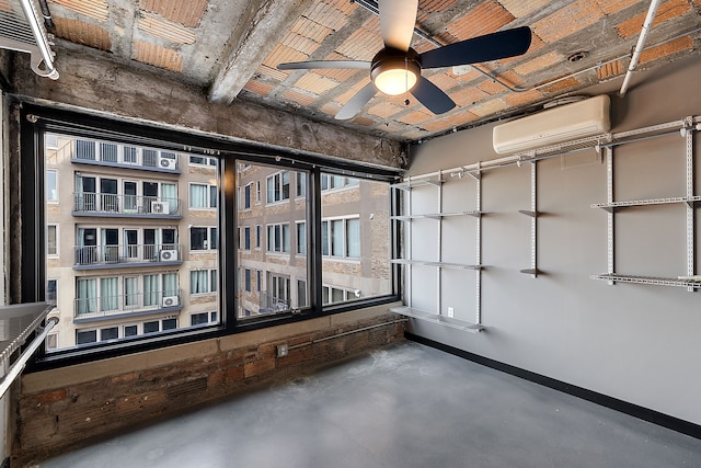 interior space featuring beam ceiling, an AC wall unit, and concrete flooring