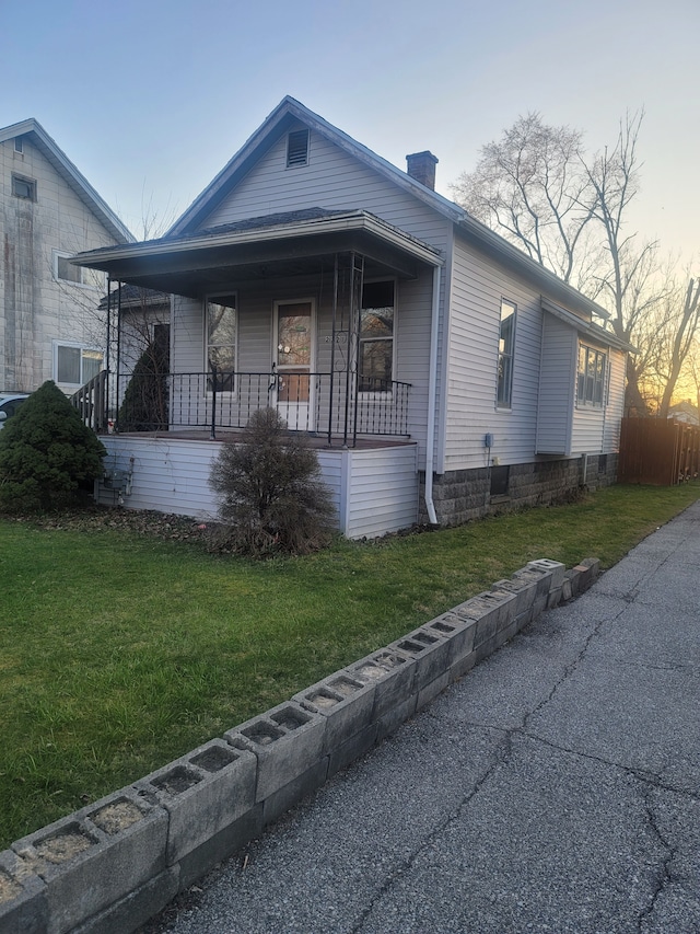 view of front of property featuring a yard and covered porch