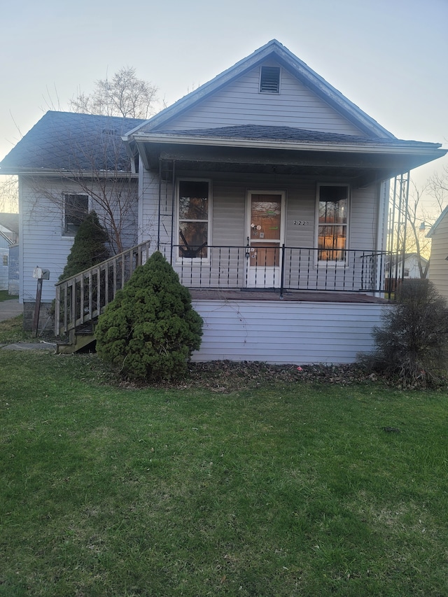 view of front of house featuring covered porch and a front lawn