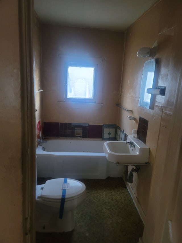 bathroom with sink, a bath, and toilet